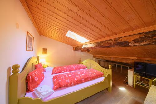 a bedroom with a bed with red pillows and a tv at Albergo Ristorante Grotto Miralago in Miralago
