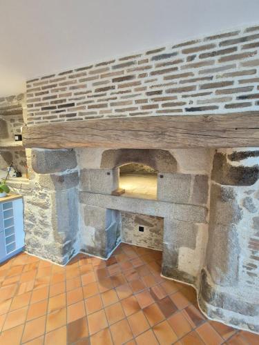 - une cuisine avec un mur en briques et une table en bois dans l'établissement Gîte Cosy & Nature - 4 Pers - proche Puy du Fou, à La Bruffière