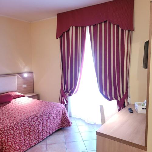 a bedroom with a bed and a large window at Hotel Eden Sul Lago in Bolsena