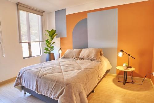 a bedroom with a bed and a table and a window at Bogotá Market & Finance Hub in Bogotá