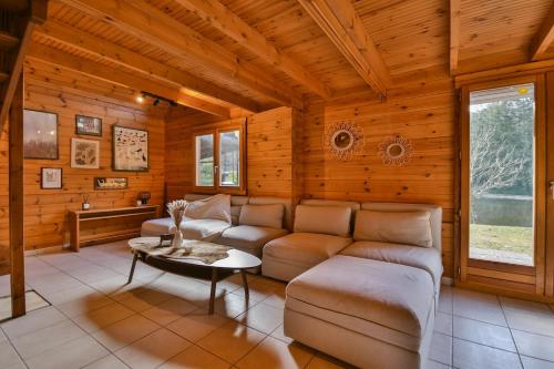 a living room with a couch and a table at Chalet du Schlossthal - Étang in Lemberg