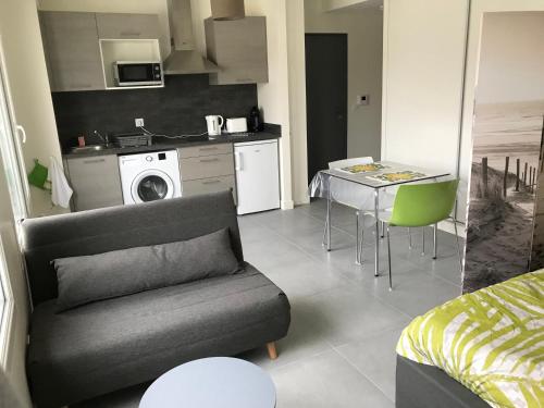 un salon avec un canapé et une table et une cuisine dans l'établissement M84 Marquer joli studio môle, à Annemasse