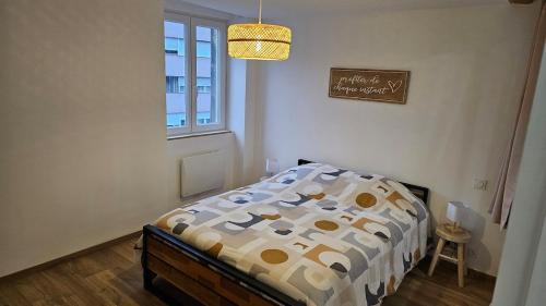 une chambre avec un lit avec une couette et une fenêtre dans l'établissement Escapade au coeur des thermes et volacans, à Royat