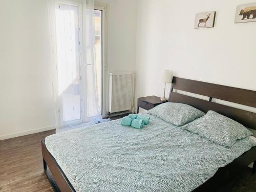 une chambre avec un lit avec deux animaux en peluche dessus dans l'établissement Terrasse au pied de la gare, à Marseille