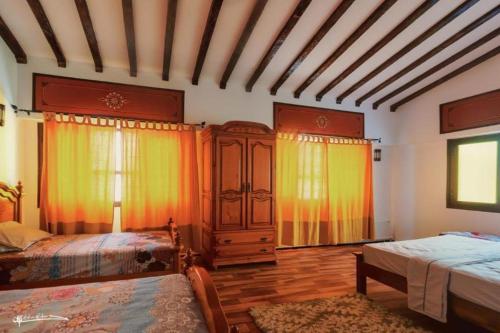 a large room with two beds and curtains at Riad Dreams chaouen in Chefchaouene
