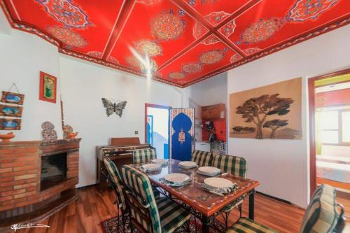 a dining room with a table and a red ceiling at Riad Dreams chaouen in Chefchaouene