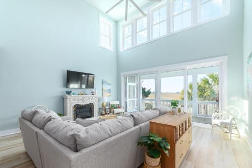 a living room with a large couch and a fireplace at New Build, walking distance to pool and beach! Perfect location on Harbor Island! in Cedar Reef Villas