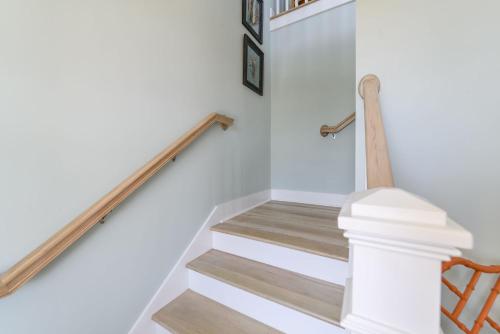 a staircase with white walls and wooden railings at New Build, walking distance to pool and beach! Perfect location on Harbor Island! in Cedar Reef Villas