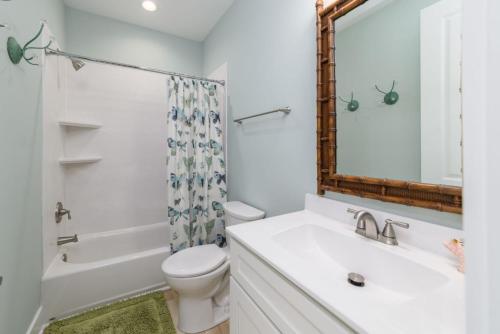 a bathroom with a sink and a toilet and a mirror at New Build, walking distance to pool and beach! Perfect location on Harbor Island! in Cedar Reef Villas