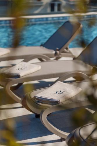 a row of chairs with a swimming pool at Saint Matthew Place in Dobrota