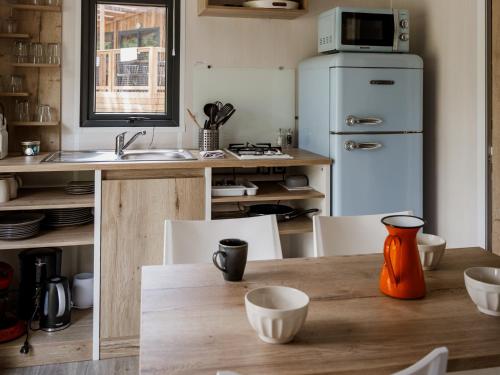 a kitchen with an orange vase on a wooden table at Whaka Lodge in Seissan