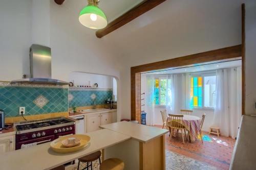 une cuisine avec une cuisinière et une table avec des chaises dans l'établissement Oasis de calme Avignon 8 personnes, à Avignon