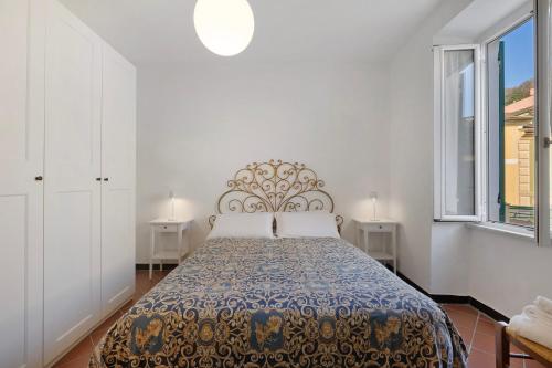 a bedroom with a bed and two windows at Casa Marcone in Moneglia