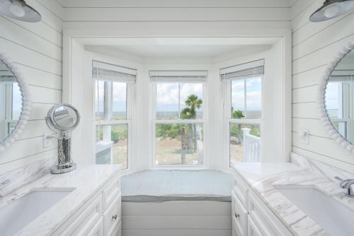 a white bathroom with two sinks and a window at One Particular Harbor - Harbor Island Oceanfront, Private Pool! in Cedar Reef Villas