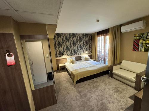a hotel room with a bed and a chair at Spa Hotel Kleptuza in Velingrad