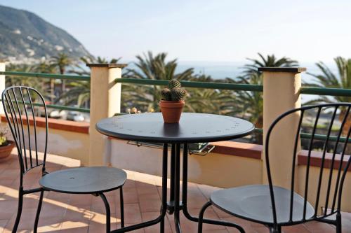 a table and two chairs on a balcony with a cactus at Casa Marcone in Moneglia