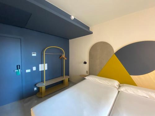 a bedroom with a bed with a yellow and blue wall at Onix Fira in Barcelona