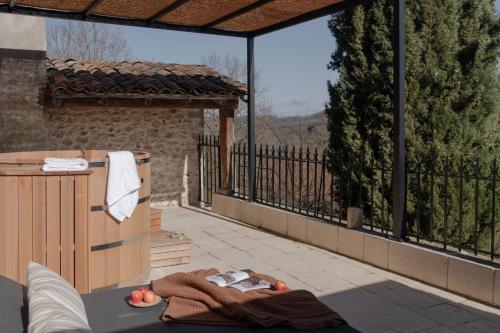 a patio with a hot tub and a balcony at MiHotel - Grenier à Sel de Pérouges in Pérouges