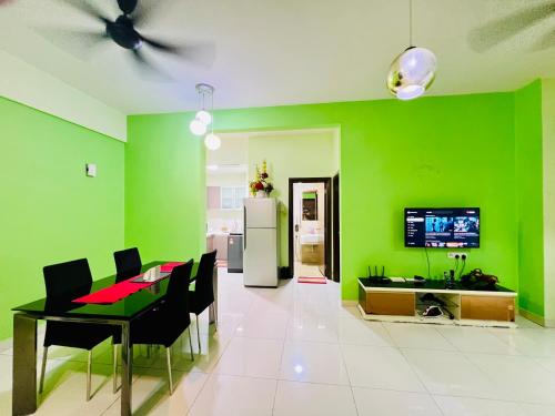 a dining room with green walls and a table and chairs at Regalia Spritz Empire Hostel in Kuala Lumpur
