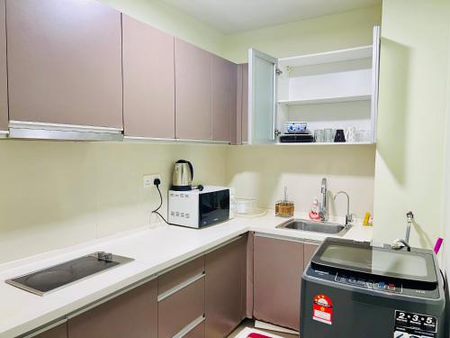 a small kitchen with a sink and a microwave at Regalia Spritz Empire Hostel in Kuala Lumpur