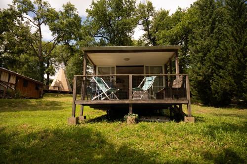 a small house with two chairs in the grass at Whaka Lodge in Seissan