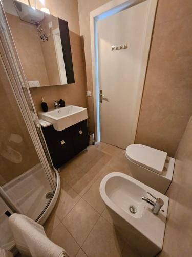 un bagno con lavandino, WC e doccia di Dani's Lakeside Apartment in Euroresidence a Garda