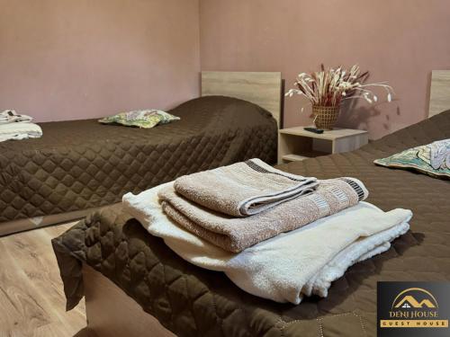 a pile of towels sitting on top of two beds at Къща за гости Дени in Chukovezer