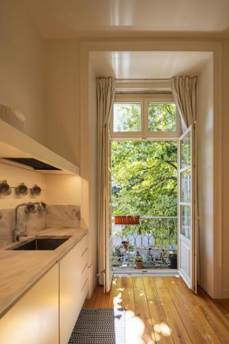 a kitchen with a sink and a large window at Antiga Casa Pessoa in Lisbon