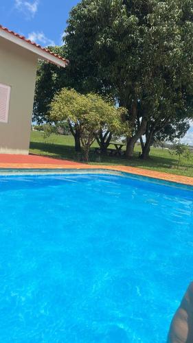 a blue swimming pool with trees in the background at Riviera Santa Cristina l in Arandu
