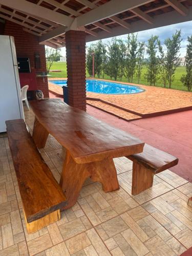 a wooden bench sitting on a patio next to a pool at Riviera Santa Cristina l in Arandu