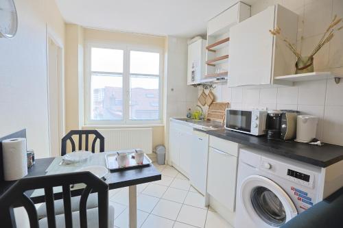 une cuisine avec une machine à laver et une table dans l'établissement L'Instant Suny Centre-ville, à Saint-Étienne