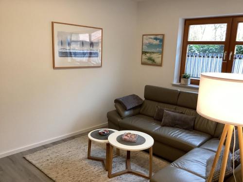 ein Wohnzimmer mit Couch und Tisch in der Unterkunft Landhaus Saterland Ferienwohnung in Sedelsberg