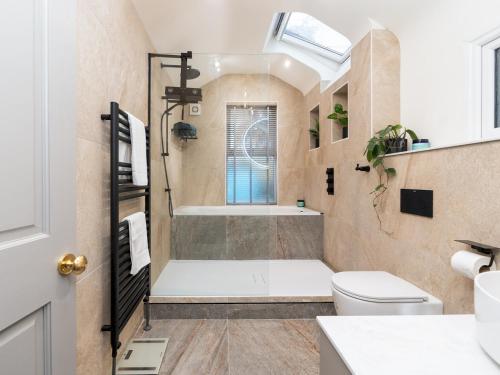 a bathroom with a tub and a toilet and a sink at Spacious one bed house with parking - Pass the Keys in Bath