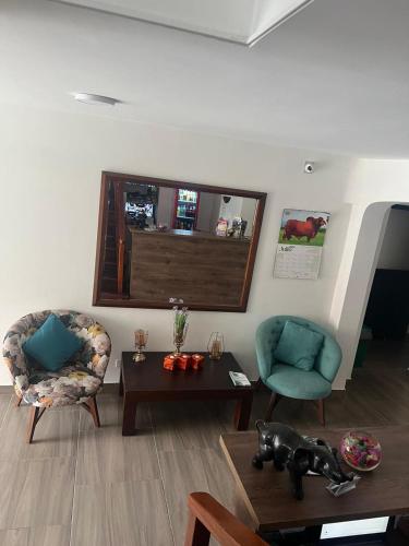 a living room with two chairs and a table at Hotel Sarape in Medellín