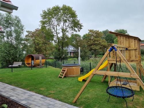 a playground with a slide and a play structure at Neues Ferienhaus für Familien mit Garten und Sauna in Butjadingen