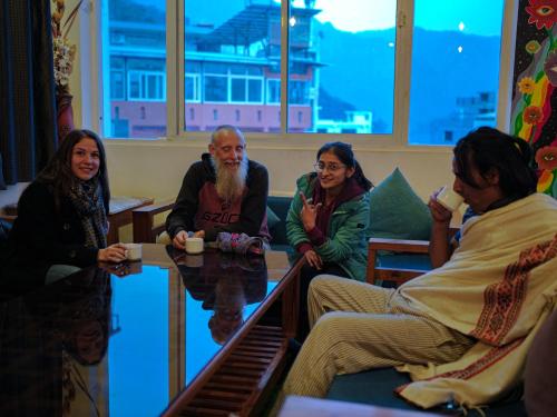 a group of people sitting around a table in a room at Skyard Premium, Tapovan in Rishīkesh