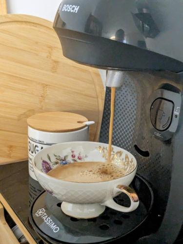 a coffee maker is making a cup of coffee at Casita im Tal - Entspannung mit Terrasse, Garten und Garage in Weilburg