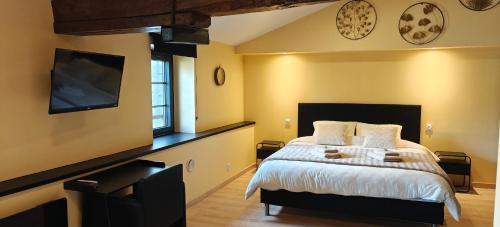 ein Schlafzimmer mit einem Bett und einem Flachbildfernseher in der Unterkunft À l'aise in Vianne