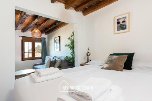 Un dormitorio con una gran cama blanca y un sofá. en MyHouseSpain - Apartamentos Cudillero, en Cudillero