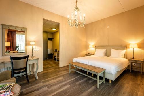 a bedroom with a bed and a desk and a chair at Hof van Putten in Putten