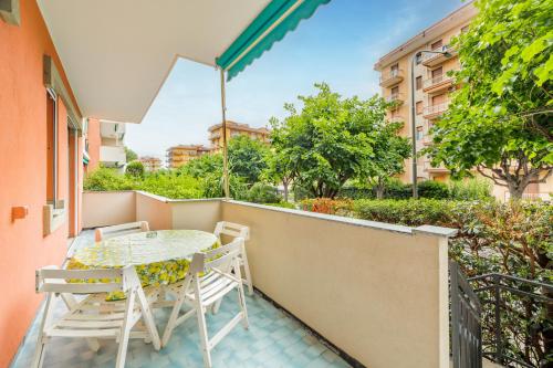 a patio with a table and chairs on a balcony at Palm House in Marina dʼAndora