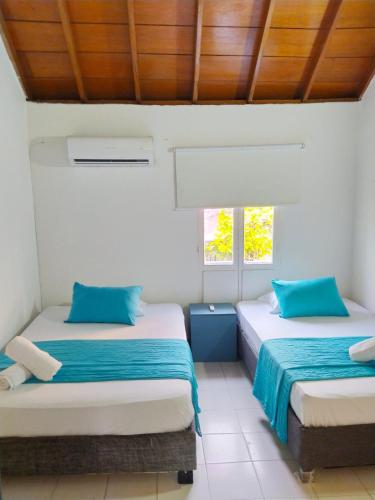 two beds in a room with two windows at Apto Centro Ciudad Amurallada - Centro Historico - Q in Cartagena de Indias
