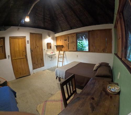 a bedroom with a bed and a table in a room at Cabañas La Escondida Mazunte in Mazunte
