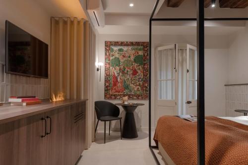 a bedroom with a bed and a desk and a chair at MiHotel - Grenier à Sel de Pérouges in Pérouges