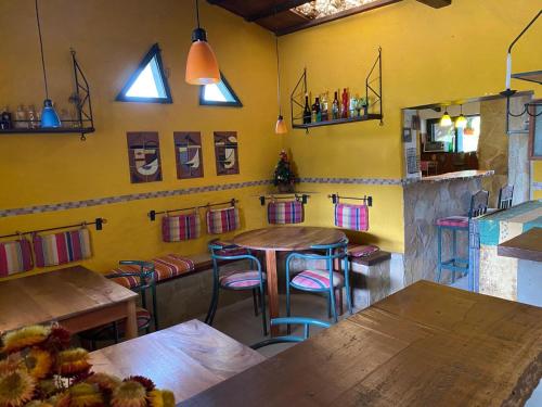 a restaurant with wooden tables and chairs in a room at Landhaus Samaipata in Samaipata