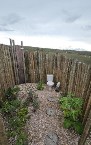 a garden with a toilet in front of a fence at Kalu Oká in Alto Paraíso de Goiás