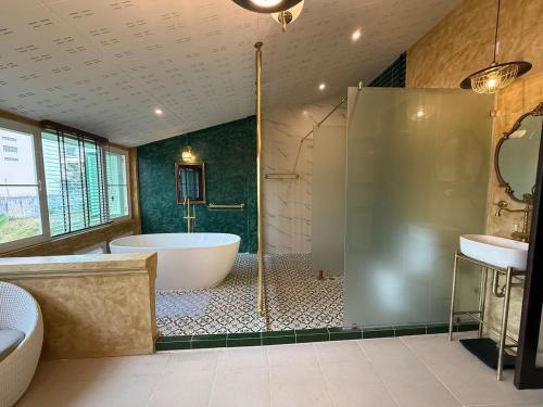 ein großes Badezimmer mit Badewanne und Waschbecken in der Unterkunft Luan Heritage Surawong in Bangkok