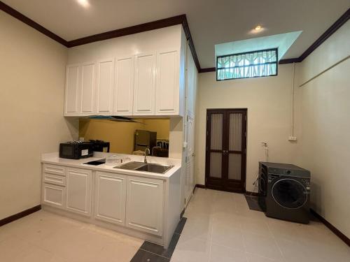 eine Küche mit Spüle und Waschmaschine in der Unterkunft Luan Heritage Surawong in Bangkok