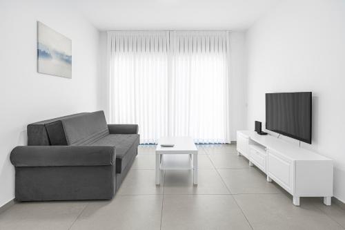 a living room with a couch and a tv at Luxury Penthouse With Sea View #65 By Hashdera Eilat in Eilat