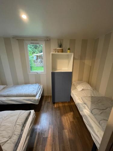 une chambre avec deux lits et une fenêtre dans l'établissement C16 - Le Domino du Ried, à Boofzheim